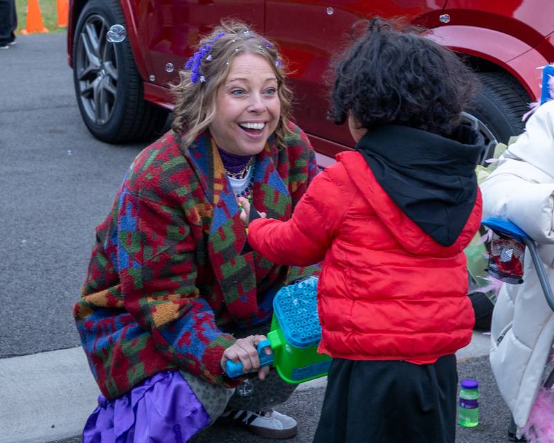 Kara Benson blows bubbles onto trick-or-treater at the trunk or treat event on Saturday, October 25, 2025 at Illinois Valley Auto Group in Peru.