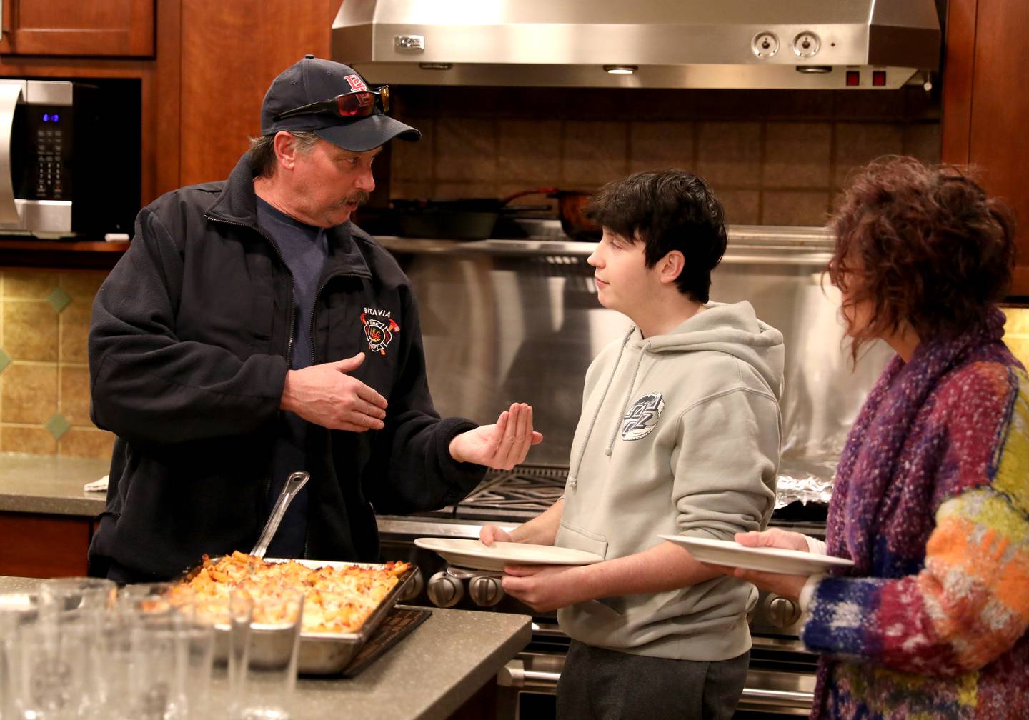 Brice Worley, 16, a junior at Batavia High School, (center) talks with Firefighter John Morris as his mom, Tami Wilson, looks on during a visit and meal at the Batavia Fire Department’s Wilson Street Station. Worley was born with a brain tumor that was dormant until 2019. He hopes to study to become a paramedic.
