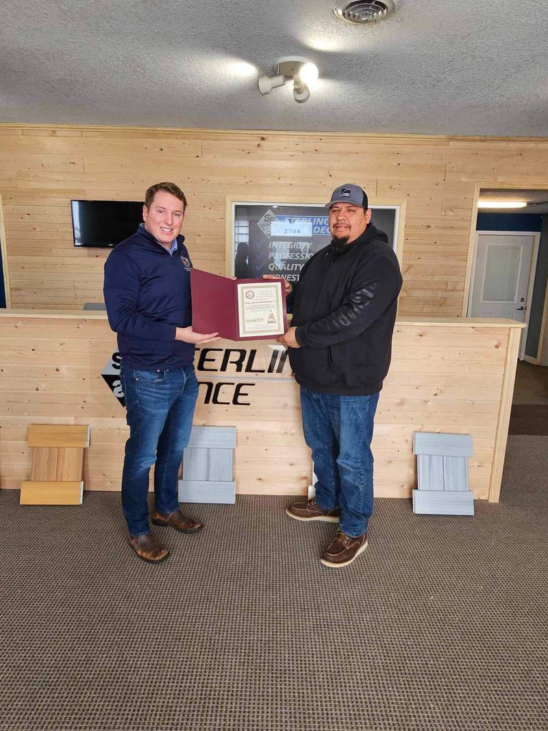 State Rep. Brad Fritts presents a certificate to Troy Hernandez, owner of Total Construction Services in Sterling.