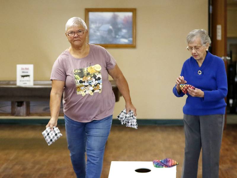 Carol Toussaint, of Johnsburg, tosses a bag while playing bags with Marie Wasil, of McHenry, Tuesday, Nov. 1, 2022, at the senior center in McHenry Township. About 70 million Social Security recipients will see a raise in their benefits to help keep up with inflation.