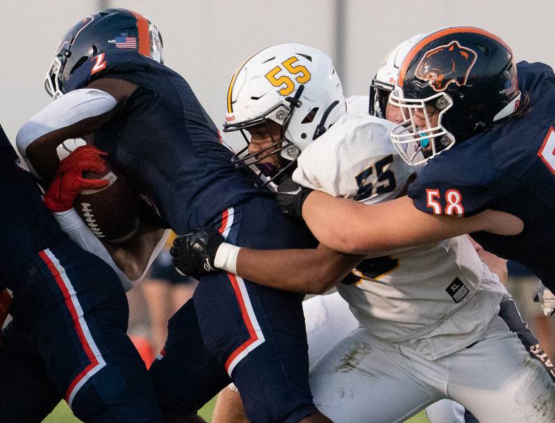 Neuqua Valley's Justen Crawford (55) hits Oswego’s Nicholas Scott (2) in the backfield for a loss during a football game at Oswego High School on Friday, Aug 26, 2022.