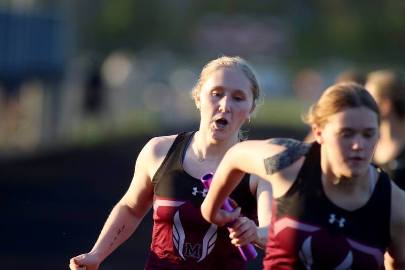 Marengo’s Rowan Kunzer, left, hands off to Lia Standish in the 800-meter relay during KRC Conference Track Meet action at Marengo High School in Marengo on Tuesday, May 6, 2025.