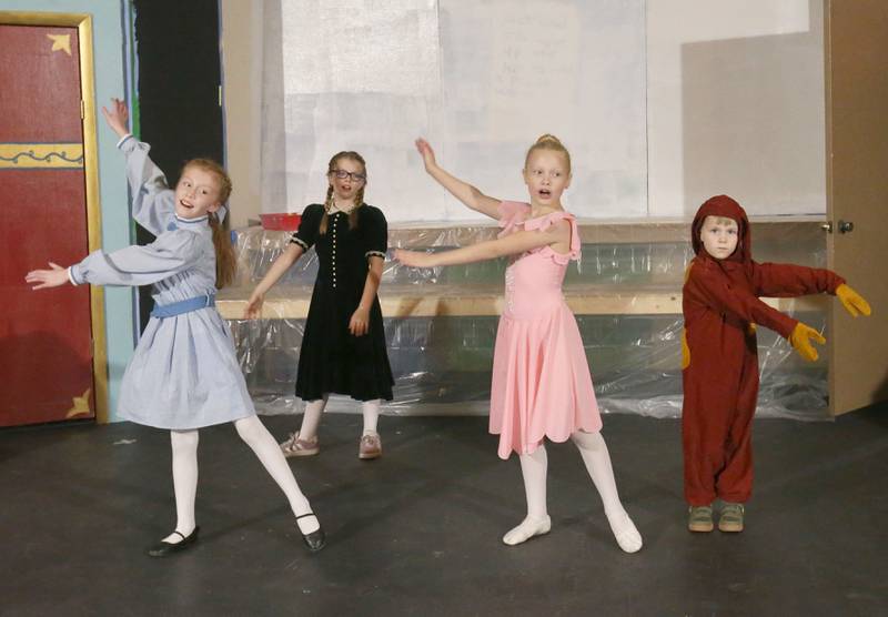 Ella Johnson as Noelle, Ellie Denton as Ivy, Hannah Noord as Clara, and Nicholas Johnson as ensemble stuffed puppy, acts out a scene during a rehearsal of “The Magic of Christmas” the Children’s Christmas Musical on Tuesday, Nov. 11, 2025 at the Prairie Art’s Center in Princeton.