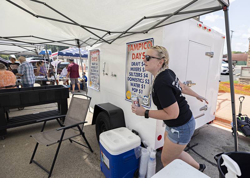 Abbey Howes runs a cold beverage to a customer Saturday, July 22, 2023 at the refreshment booth of Tampico Days. Howes was excited to work the fest for the first time this year.