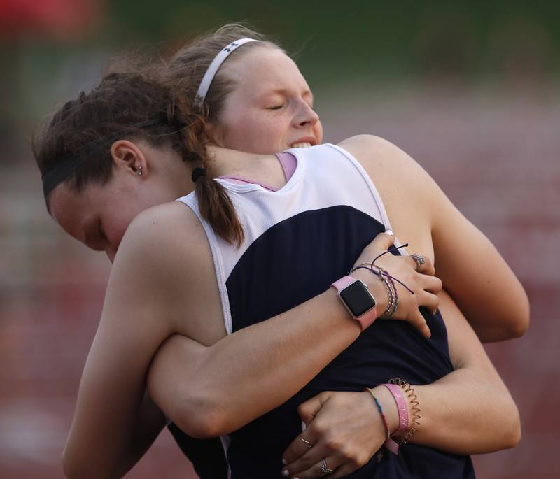 Cary-Grove’s Lindsey Kownick, left, is hugged by her teammate Mya Bajramovic after finishing the 100 meter hurdles during the IHSA Class 3A Huntley Girls Track Sectional Wednesday,  May 11, 2022, at Huntley High School.
