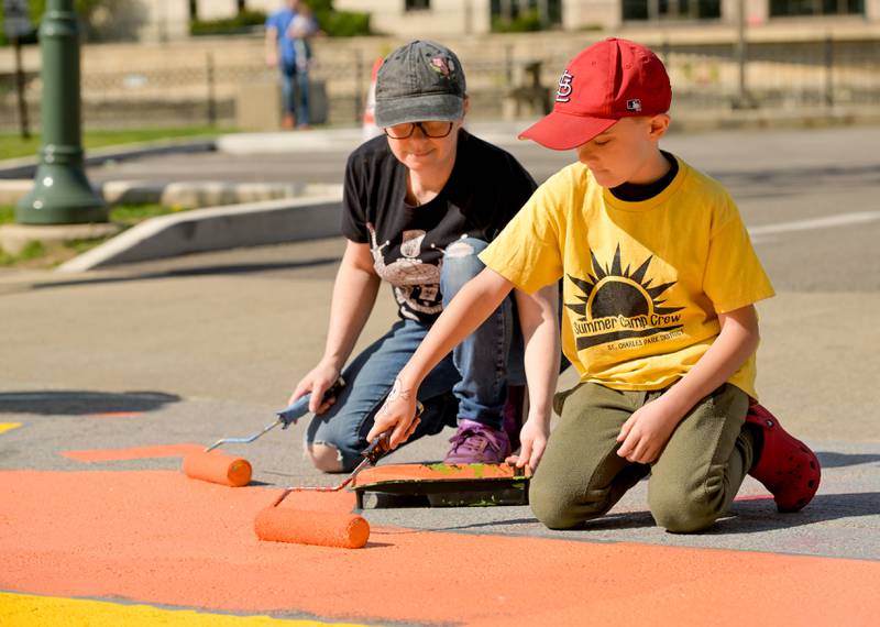 Ali Lanthrum and her nephew Joe Lanthrum, 9 of St. Charles participate in the St. Charles Art Council’s “Paint the Riverside” to change out the street mural in the intersection of Walnut and Riverside Avenues on Saturday, May 10, 2025 in St. Charles.