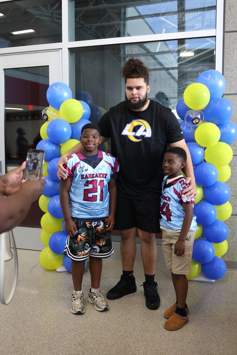 Two Kankakee youth football players D.J., 10, left, and Denim Magee, 8, pose for a photo with Keagen Trost, a 2019 Kankakee High School grad, during a celebration held for him at the school on May 4, 2026, following him being drafted into the NFL to the Los Angeles Rams.