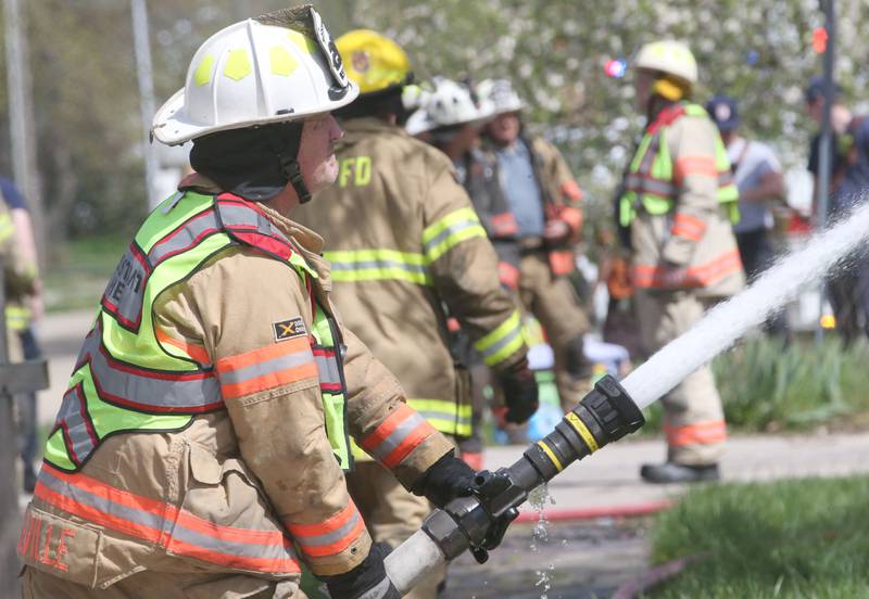 Leland assistant fire chief sprays water on a house fire in the 300 block of Maple Street on Monday, April 22, 2024 in Earlville. The fire happened around 10a.m.