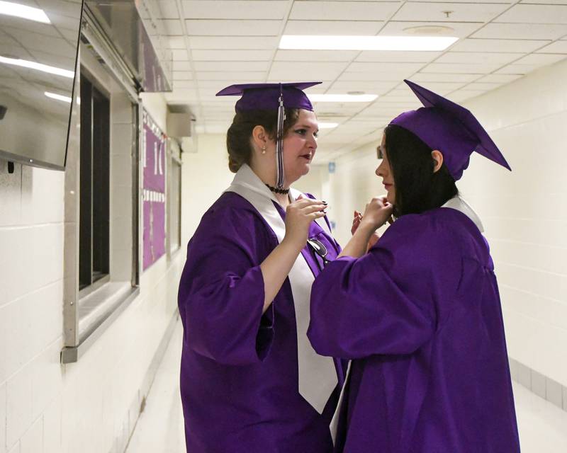Downers Grove North senior Sophia Gallovitch, left, helps Kate Houlaha with her graduation cap before the start of the graduation ceremony held at Downers Grove North High School on Sunday May 19, 2024.