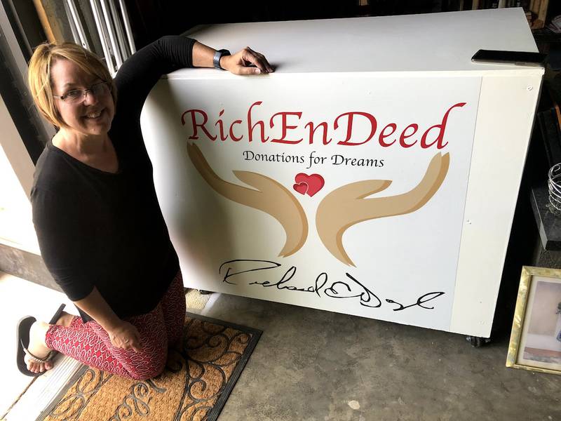 Joette Doyle, founder of the Plainfield nonprofit RichEnDeed, poses with the store counter with RichEnDeed's logo that a volunteer made for her. RichEnDeed lost its space for its free store in October, but Doyle is confident someone in the community will offer space for minimal rent.