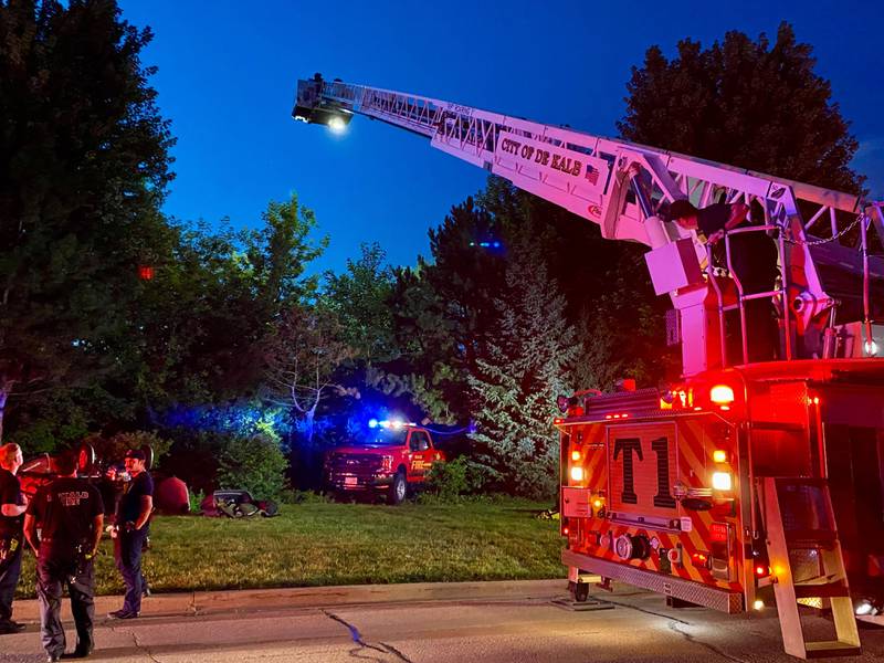 DeKalb firefighters are hoisted into the air on a ladder truck to help provide light to emergency divers undertaking a water rescue on Sunday, July 27, 2025, in the 600 block of Ridge Drive in DeKalb.