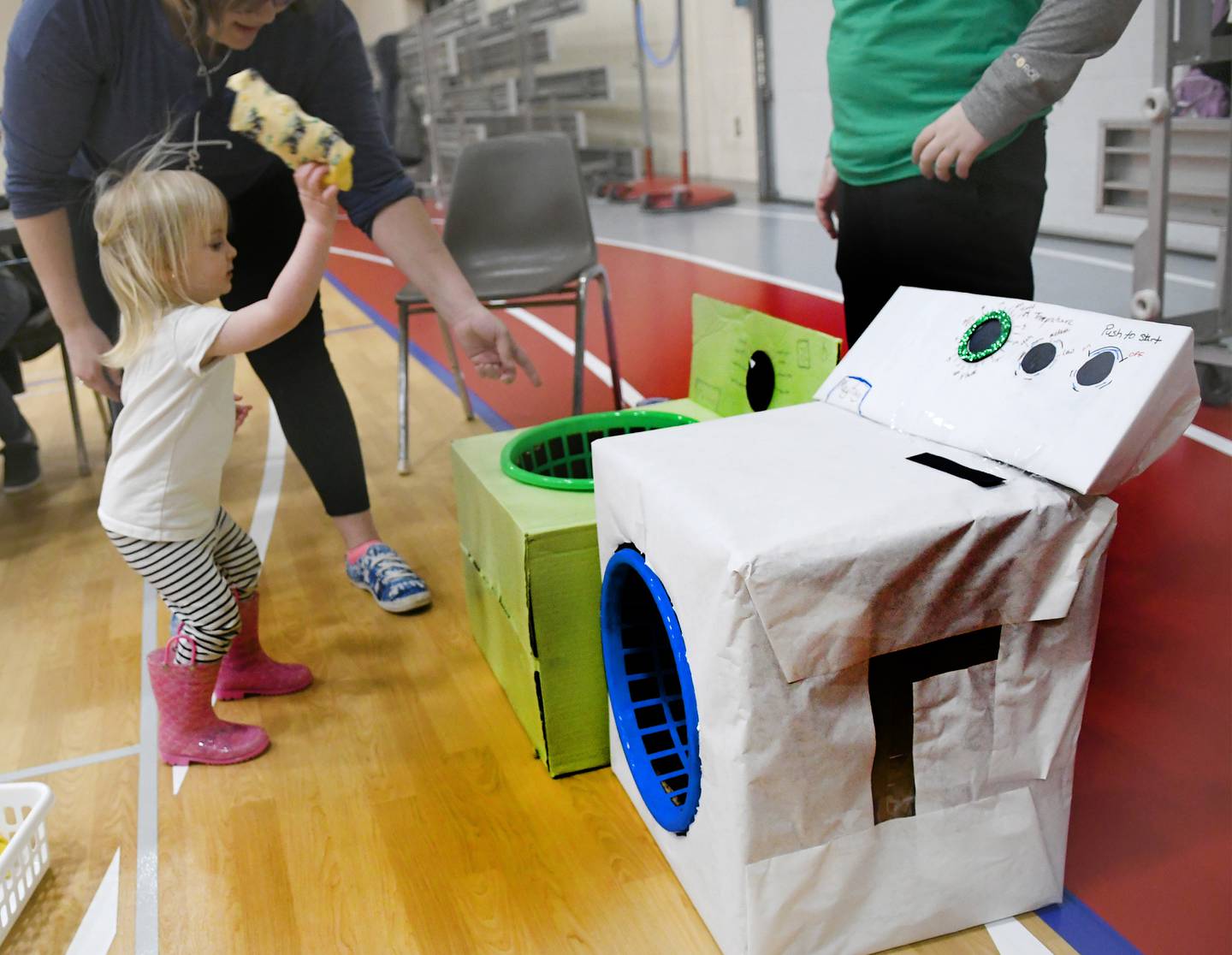Eileen Frewin, 2, of Oregon, tosses a sock into a cardboard dryer at the 4-H Penny Carnival on Saturday, March 18. The Ogle County Clovers 4-H Club offered this game for participants.