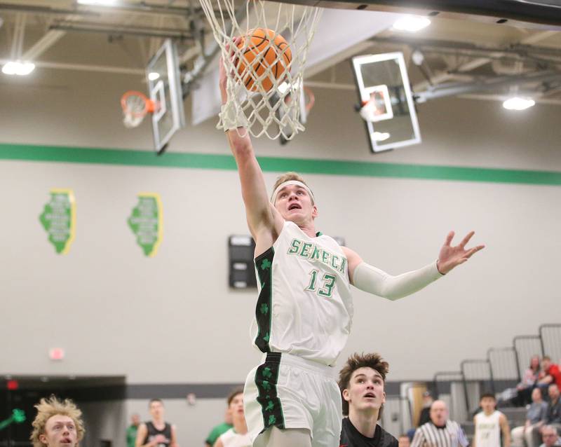 Seneca's Paxton Giertz scores on a layp over Woodland's Nolan Price on Friday, Feb. 14, 2025 at Seneca High School.