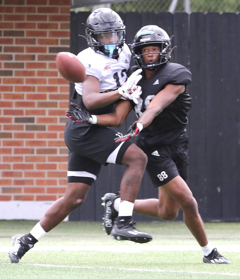 Northern Illinois Huskies cornerback Ty Myles (left) and wide receiver Malik Armstrong fight for a 50-50 ball Tuesday, Aug. 9, 2022, during practice in Huskie Stadium at NIU.