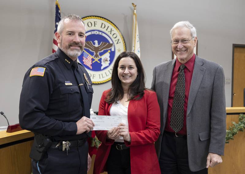 Dixon police chief Steve Howell (left) and Dixon mayor Glen Hughes accepts a check from Ken Nelson marketing director Mandy Hinkey Monday, Dec. 18, 2023 for the purchase of a new K9.