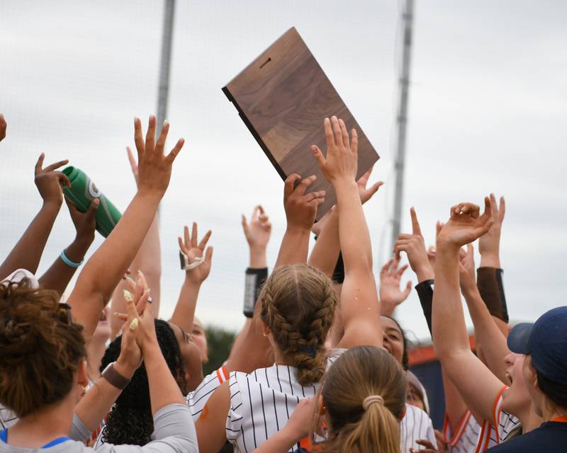 The Oswego softball team celebrates with the regional final plaque after securing a win over Benet Academy during the regional final game on Friday May 22, 2026, held at Oswego High School.