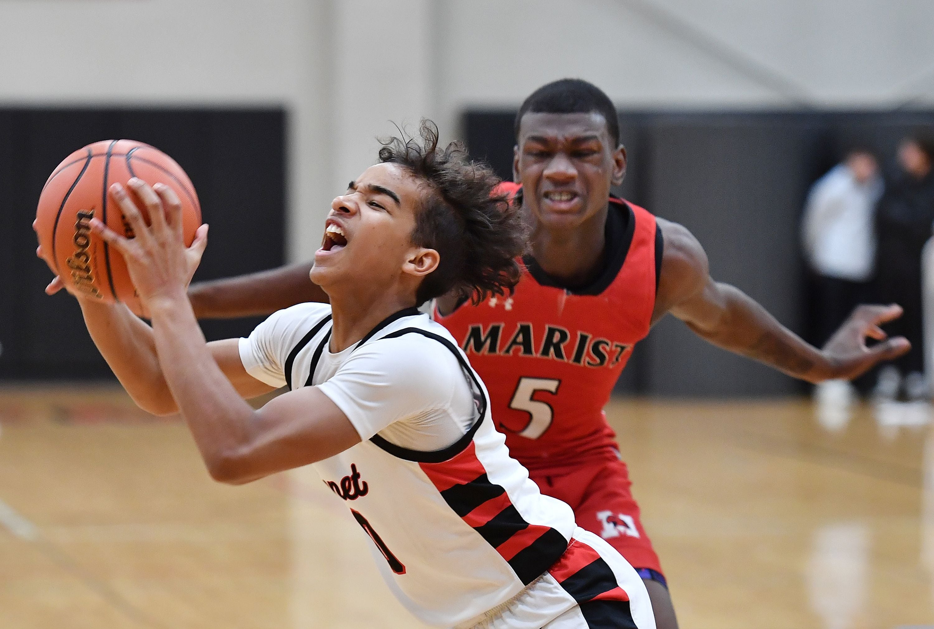 Benet's Blake Fagbemi reacts to contact from Marist's Stephen Brown (5) during a game on Dec. 15, 2023 at Benet Academy in Lisle.