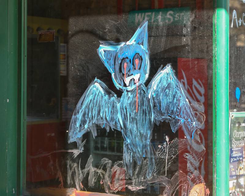 A bat is painted on a window on Saturday Oct. 21, 2023, during the Halloween Window painting event held in downtown Downers Grove.