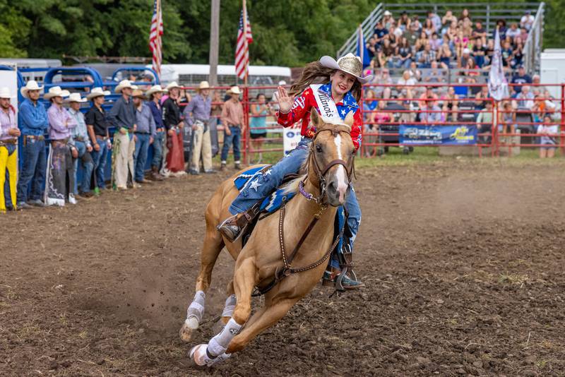 Korra Wilson, who won the title of Illinois Little Britches Rodeo Jr. Princess, waves to the crowd at the start of the LaSalle County 4H Fair rodeo on July 11, 2025 in Ottawa.