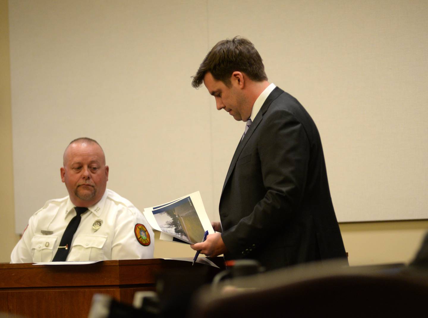 Mount Morris Fire Captain Ryan Fletcher looks at photos as he is questioned by defense attorney John Kopp at the Matthew Plote trial at the Ogle County Judicial Center in Oregon on Tuesday, March 19, 2024.