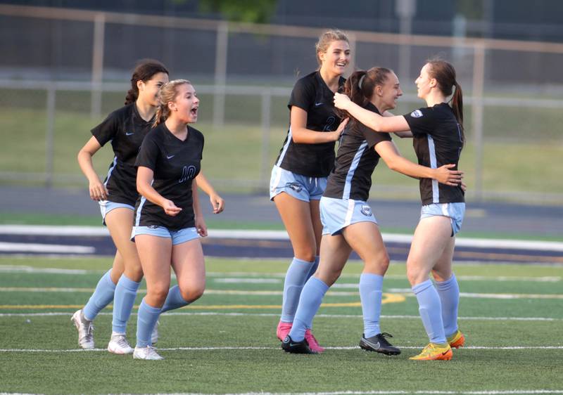 St. Charles North players celebrate a goal by teammate Laney Stark (second from right) during a Class 3A West Chicago Sectional semifinal against Geneva on Tuesday, May 23, 2023.