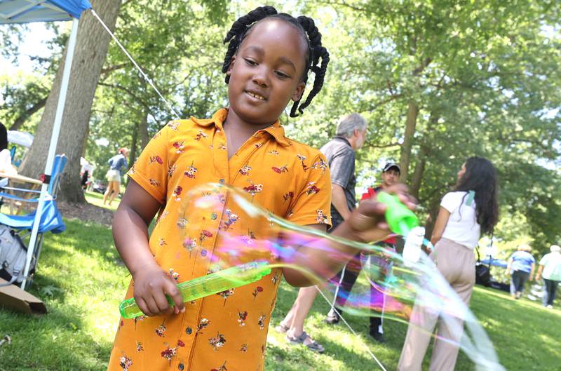 Alaunie Baker-Mcelroy, 7, from Sycamore plays with some bubbles during the second annual Juneteenth celebration Sunday, June 19, 2022, at Hopkins Park in DeKalb.