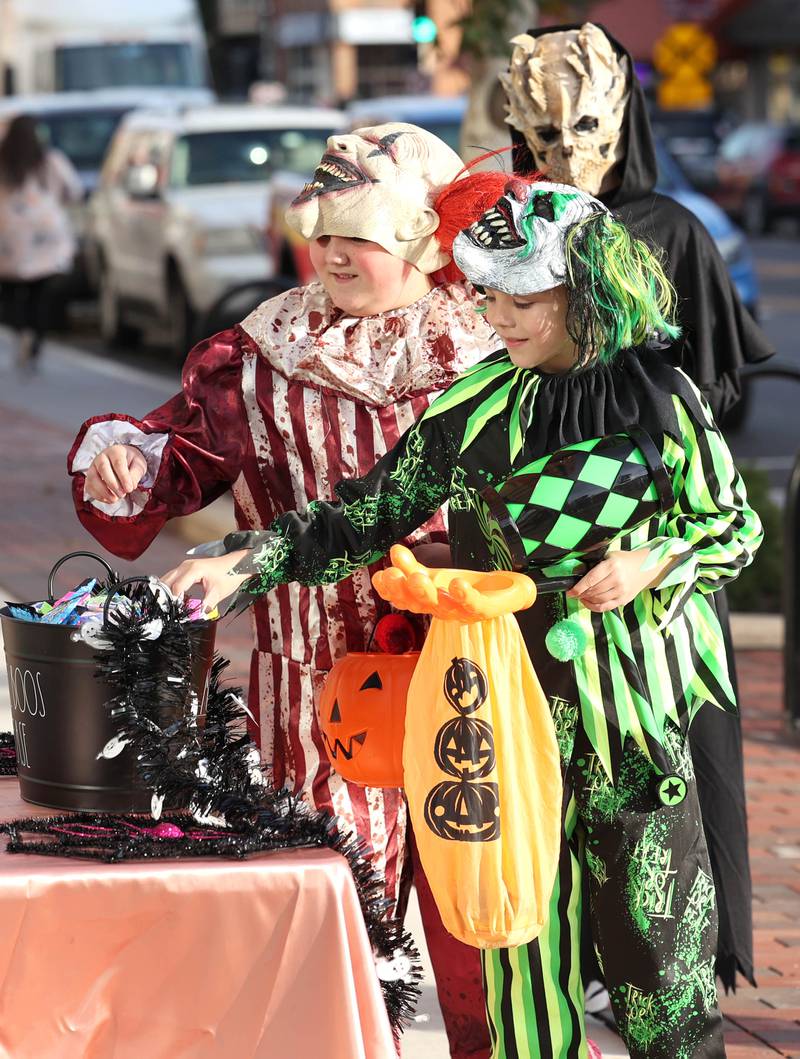 Trick-or-treaters get some candy from the Canvas Hair Studio on Lincoln Highway in downtown DeKalb Thursday, Oct. 27, 2022, during the Spooktacular trick-or-treating event hosted by the DeKalb Chamber of Commerce.