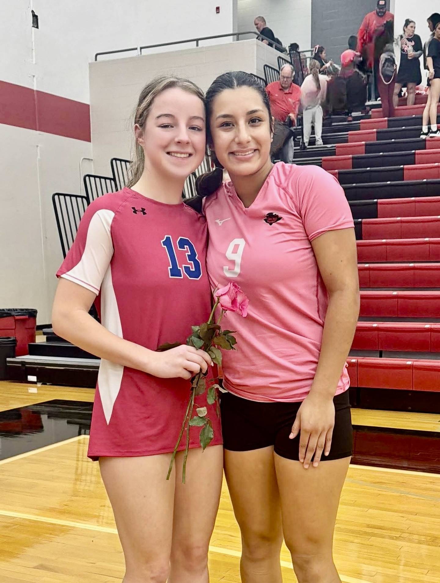 Princeton junior Bella Clevenger r(left) eceived a rose from Hall senior Natalia Zamora, a club volleyball teammate, on Breast Cancer Awareness Night Thursday at Hall. Clevenger was diagnosed with Acute Lymphoblastic Leukemia at age 2,
