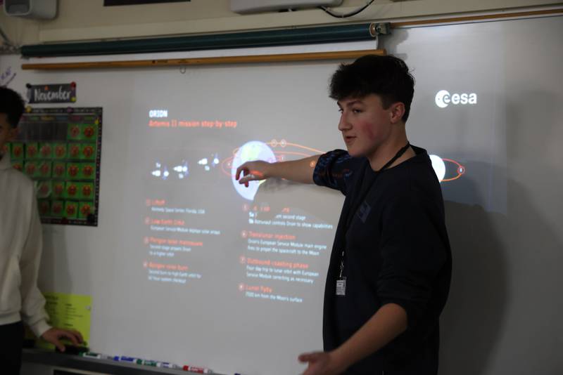 Huntley High Senior Nolan Laird explains the flight path of the Artemis II space mission to third graders in Mrs. Gross's class at Martin Elementary School in Lake in the Hills Nov. 14.