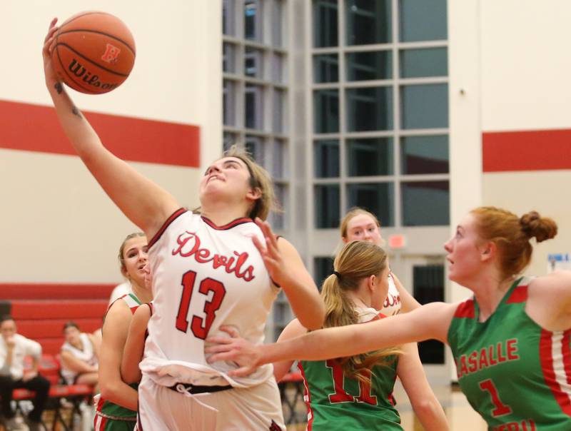 Hall's Mckenna Christiansen scores her 1000th point on this drive to the hoop past L-P's Addison Duttlinger on Monday, Dec. 11, 2023 at Hall High School.