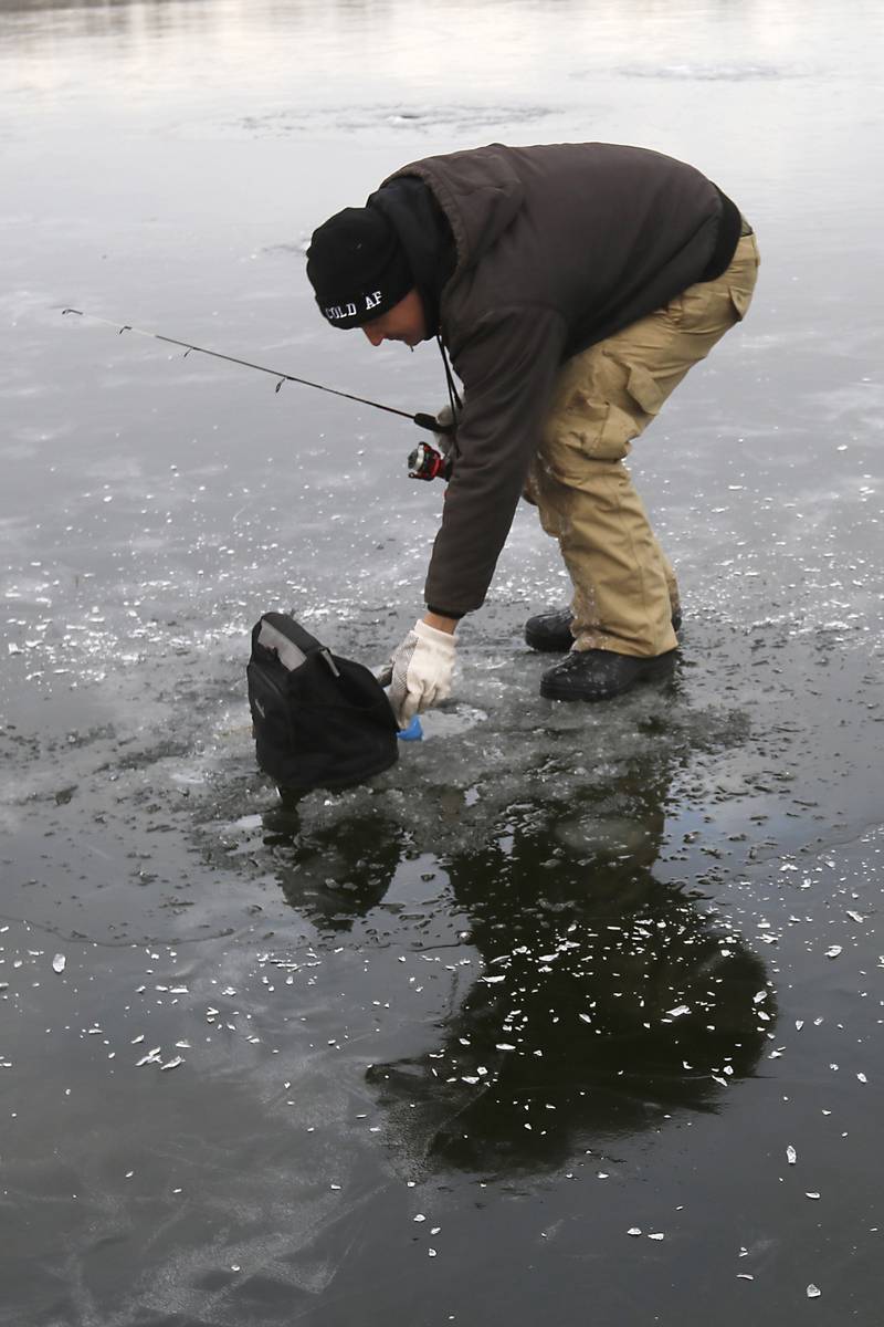 David Leach Jr., checks his fish finder while while ice fishing on Wednesday, Jan. 8, 2025, on the westside of Crystal Lake near the Lakewood Village Hall.
