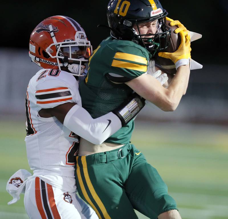 Hersey's Brandon Jenkins (20) wraps up Fremd's Brennan Saxe (10) Friday September 1, 2023 in Palatine.