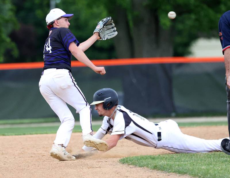 Sycamore's Trenton Meisch slides in safely with a stolen base as Dixon's Brady Feit takes the throw Thursday, May 29, 2025, during their Class 3A regional semifinal game at Freeport High School.
