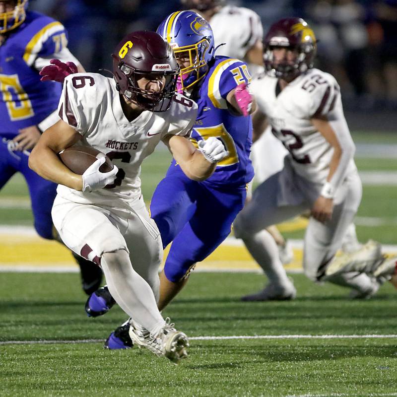 Richmond-Burton's Hunter Carley runs the ball as Johnsburg's Ryan O'Dell chases him down during a Kishwaukee River Conference football game on Friday, Sept. 12, 2025, at Johnsburg High School.