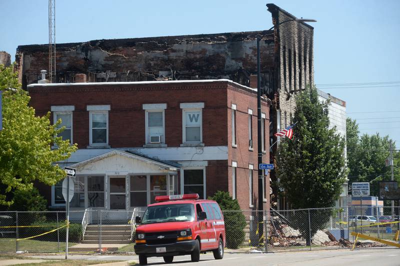A Sterling fire department vehicle was parked west of the apartment building at 406 E. Third St. in Sterling, on Monday, July 10, 2023. The building, including two others on each side, have been cordoned off with a metal fence, and police tape remains in a two-block area southwest of the scene, including a portion of the municipal parking lot across Fourth Avenue.