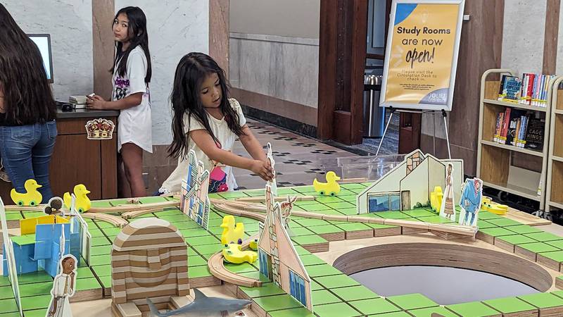 jazmin Ceballos, 5, of Joliet, explores the town of  Iggy Peck, architect on Wednesday, June 21, 2023, at the Ottawa Street branch of the Joliet Public Library. Iggy Peck is one of the characters in “The Questioneers: Read. Question. Think. PLAY!” exhibit based on the Questioneers book series authored by Andrea Beaty and illustrated by David Roberts. The traveling, interactive exhibit is available during library hours through July 29.