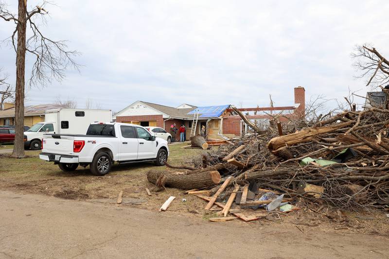 Debris is piled high along Elmwood Drive in Aroma Township on March 14, 2026, as crews worked to clean up following the March 10 tornado in Kankakee County.