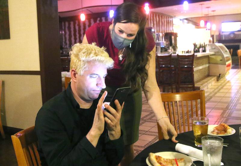 DeKalb mayoral candidate Carolyn Morris checks the election returns with Daniel Sherrill, of DeKalb, Tuesday as results begin to come in during an election night party at Fanatico in DeKalb.