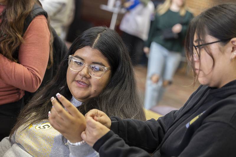Mariana Diaz gets help from Vanesa Abarca tying a friendship bracelet Wednesday, Nov. 13, 2024, at SVCC.