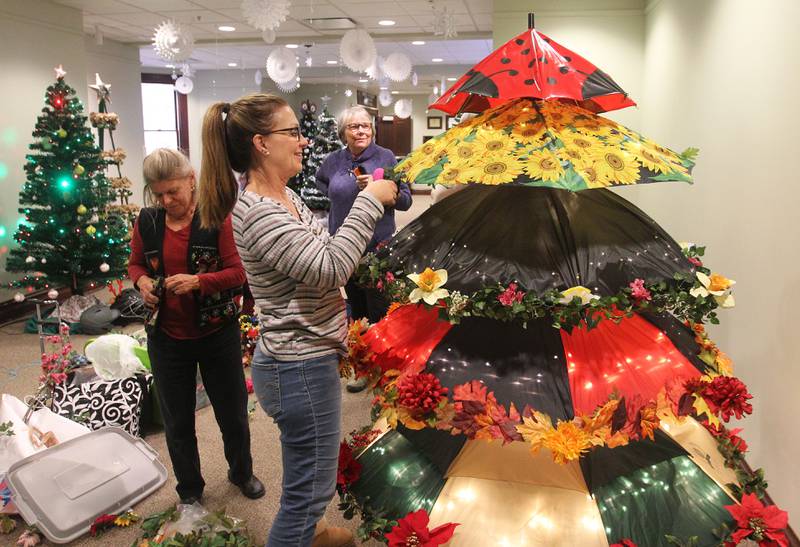 Nancy Musselman, of Grayslake, Cheryl Lettow, of Round Lake Beach and Carol Wegner, of Grayslake work together putting up the Grayslake Greenery Garden Club tree for the Giving Trees exhibit at the Grayslake Heritage Center & Museum