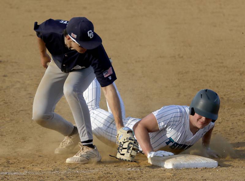 Cary-Grove's Hayden Dieschbourg tries to tag Woodstock North's Brady Rogers as he dives back to first base during a nonconference baseball game on Monday, March 30, 2026, at Woodstock North High School.
