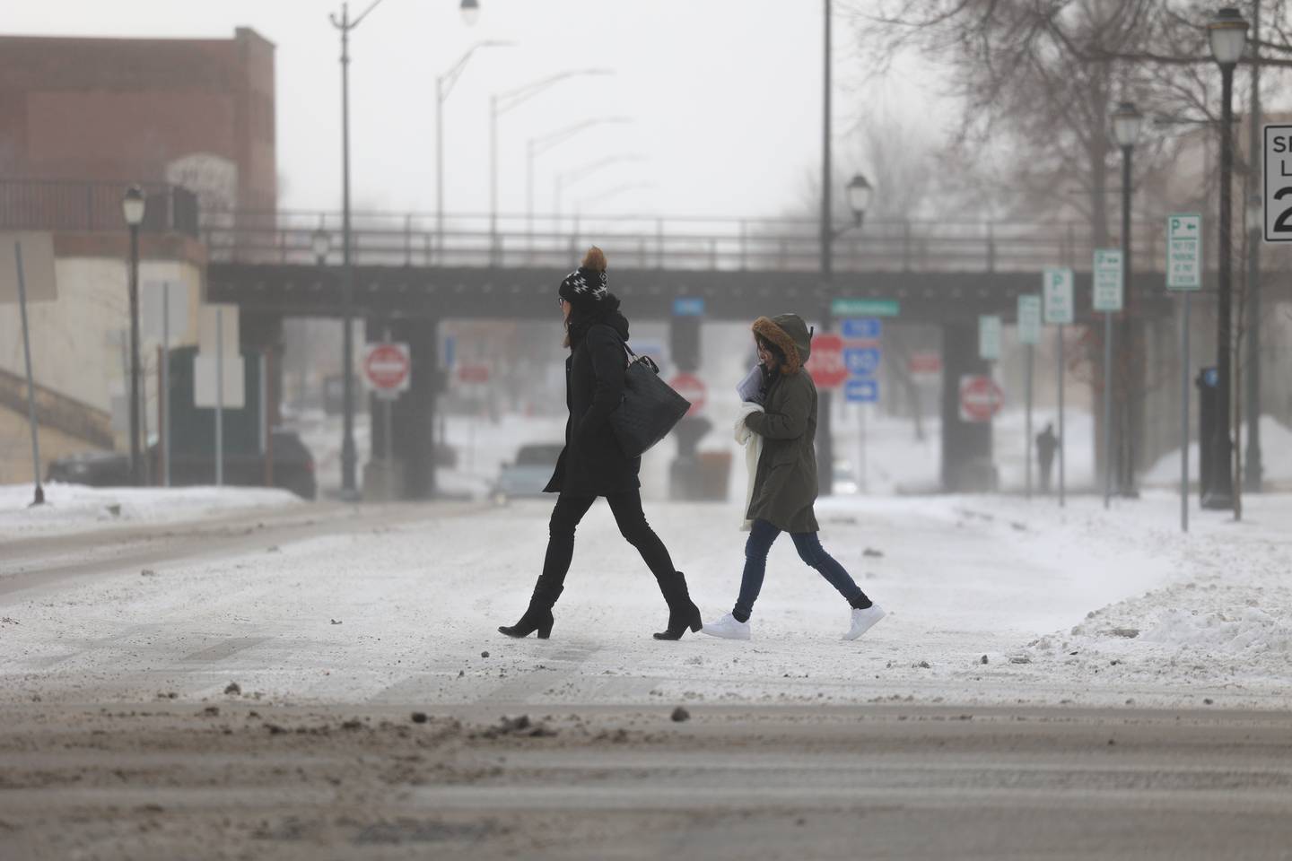 Pedestrians walk along West Jefferson Street in Downton Joliet as temperatures fall below zero degrees.