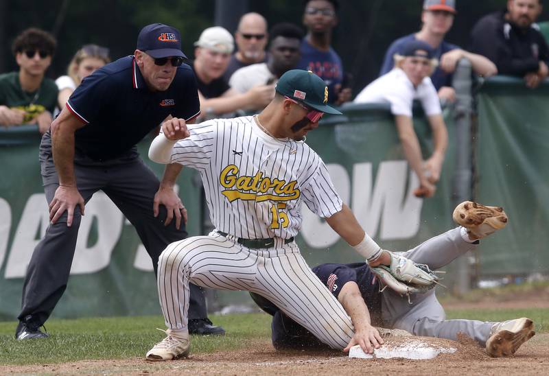 Crystal Lake South's Yandel Ramirez tries to tag Cary-Grove's Keenan Krysh as he slides into third base during the IHSA Class 3A Grayslake Central Sectional Championship baseball game on Saturday, June 7, 2025, at Grayslake Central High School.