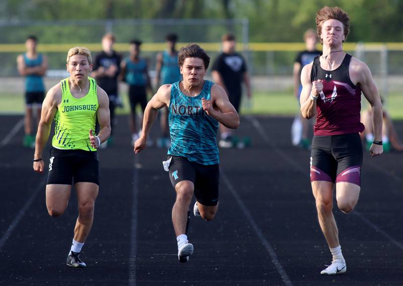 From left, Johnsburg’s Nick LoPresti, Woodstock North’s Mark Duenas, and Marengo’s Josh Holst race the 100-meter dash during Kishwaukee River Conference track meet action at Marengo Tuesday night.