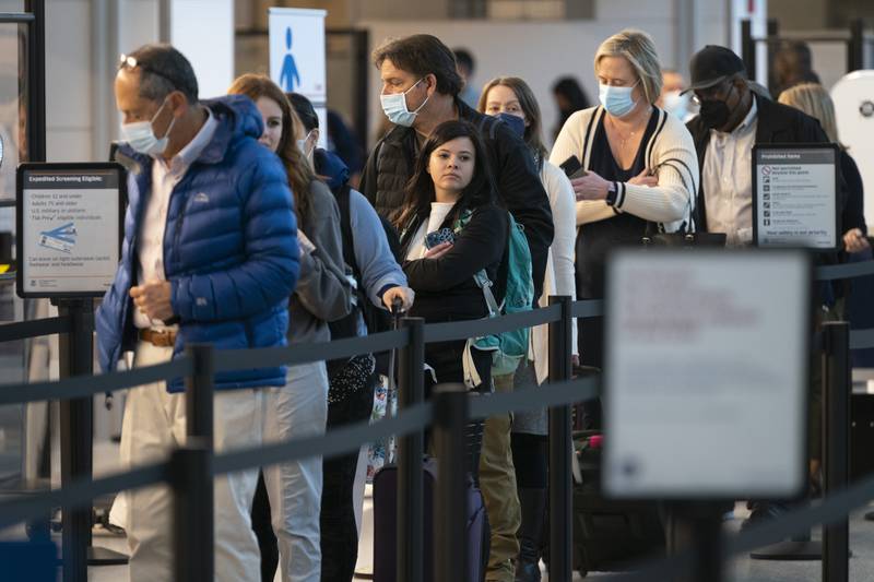 Passengers wait in line at the security checkpoint at Ronald Reagan Washington National Airport, Tuesday, April 19, 2022, in Arlington, Va. The Justice Department is filing an appeal seeking to overturn a judge’s order that voided the federal mask mandate on planes and trains and in travel hubs. The notice came minutes after the Centers for Disease Control and Prevention asked the Justice Department to appeal the decision handed down by a federal judge in Florida earlier this week. (AP Photo/Evan Vucci)