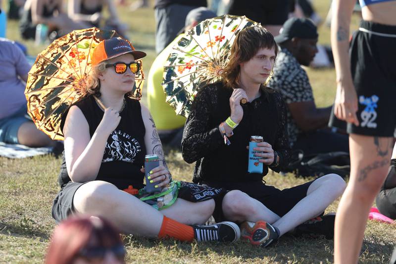 Noelle and Zoe Philipps use umbrellas to shade themselves from the sun at Riot Fest on Saturday, Sept. 21, 2024 in Chicago.
