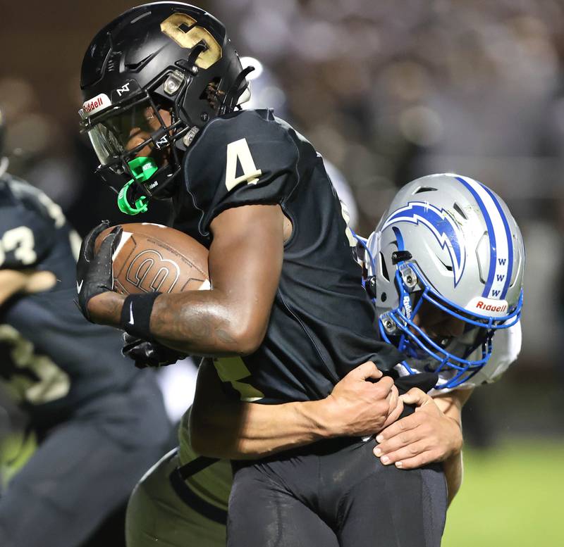 Sycamore's Tyler Curtis tries to break free from a Woodstock tackler during their game Friday, Sept. 8, 2023, at Sycamore High School.