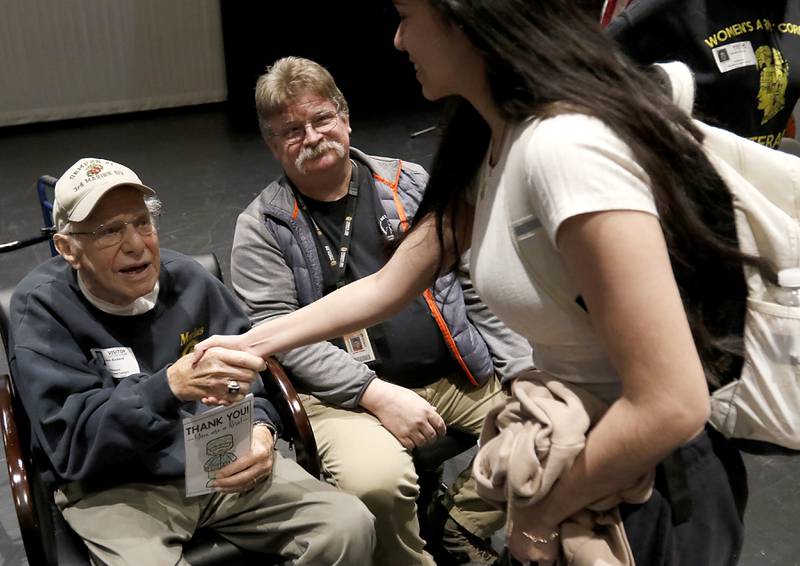 U.S. Marine World War II veteran John Rickerd shakes hands with a student after talking about Iwo Jima during the Veterans Day event on Monday, Nov.11, 2023, at the Upper Campus of McHenry High School.