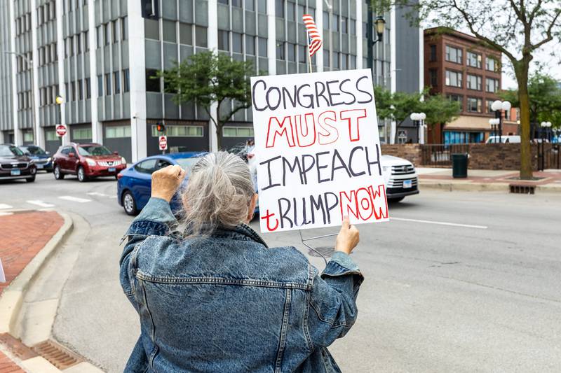 An attendee holds up a sign at the Good Trouble Lives On event in Downtown Joliet on July 17, 2025.