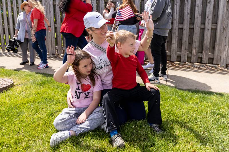 Plainfield resident Brittany Schreck, and her children Colette and Luke, wave as the Plainfield American Legion Marne Post 13 Memorial Day Parade steps off from Ira Jones Middle School on May, 26, 2025.